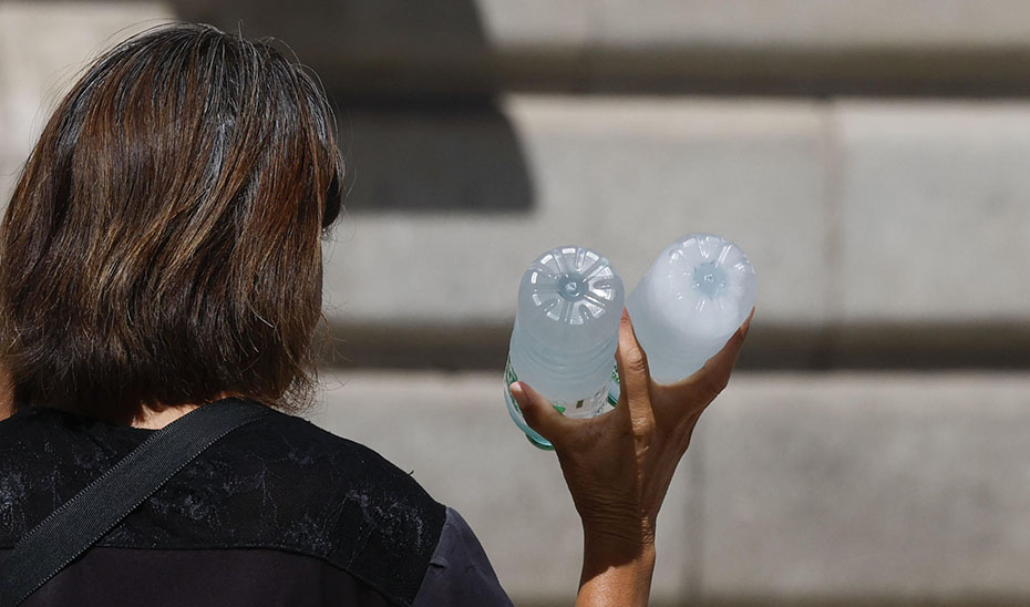 Una mujer porta botellas de agua para combatir el calor (Agencia EFE).